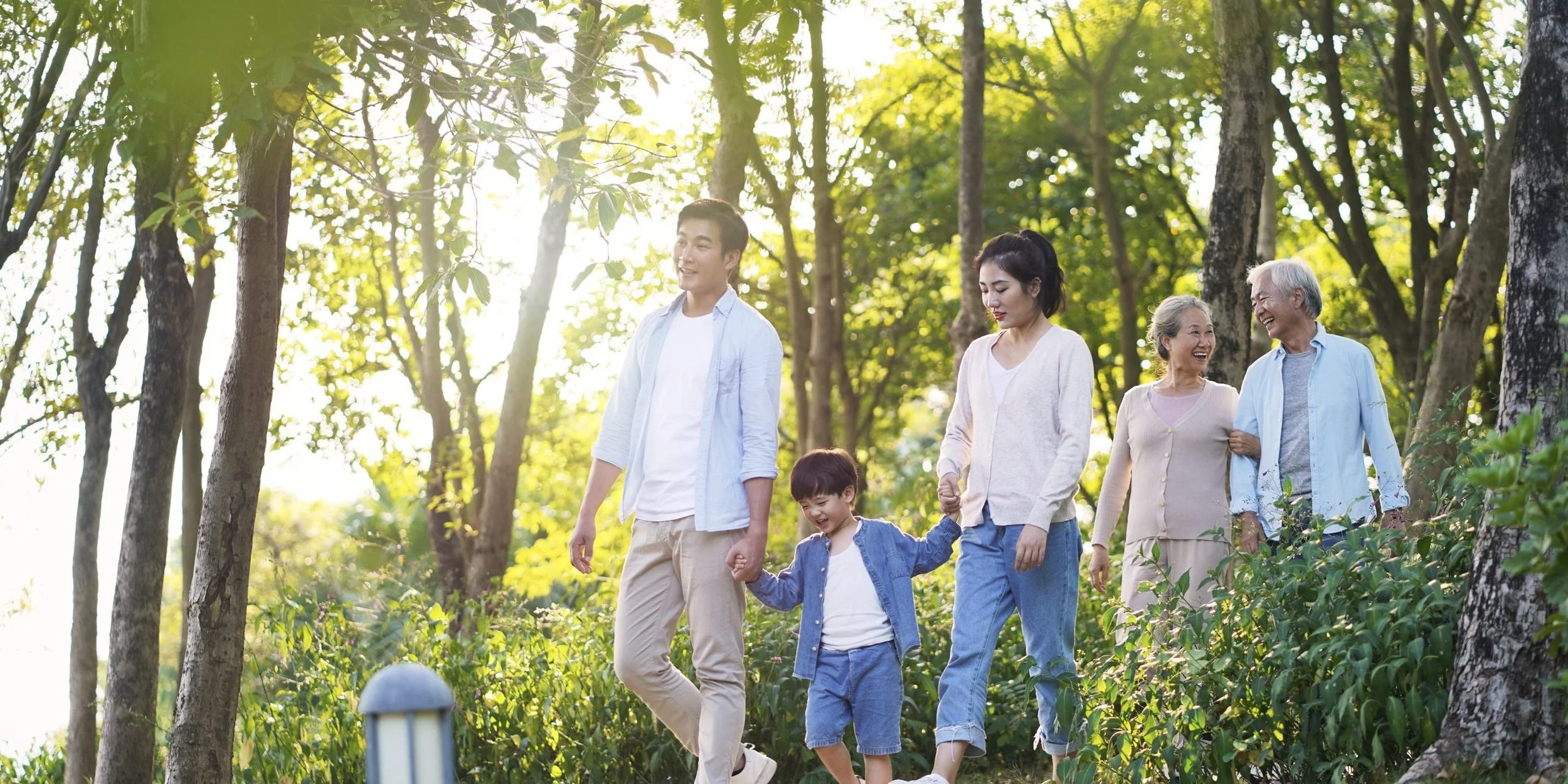 Happy multigenerational Asian family walking outdoors