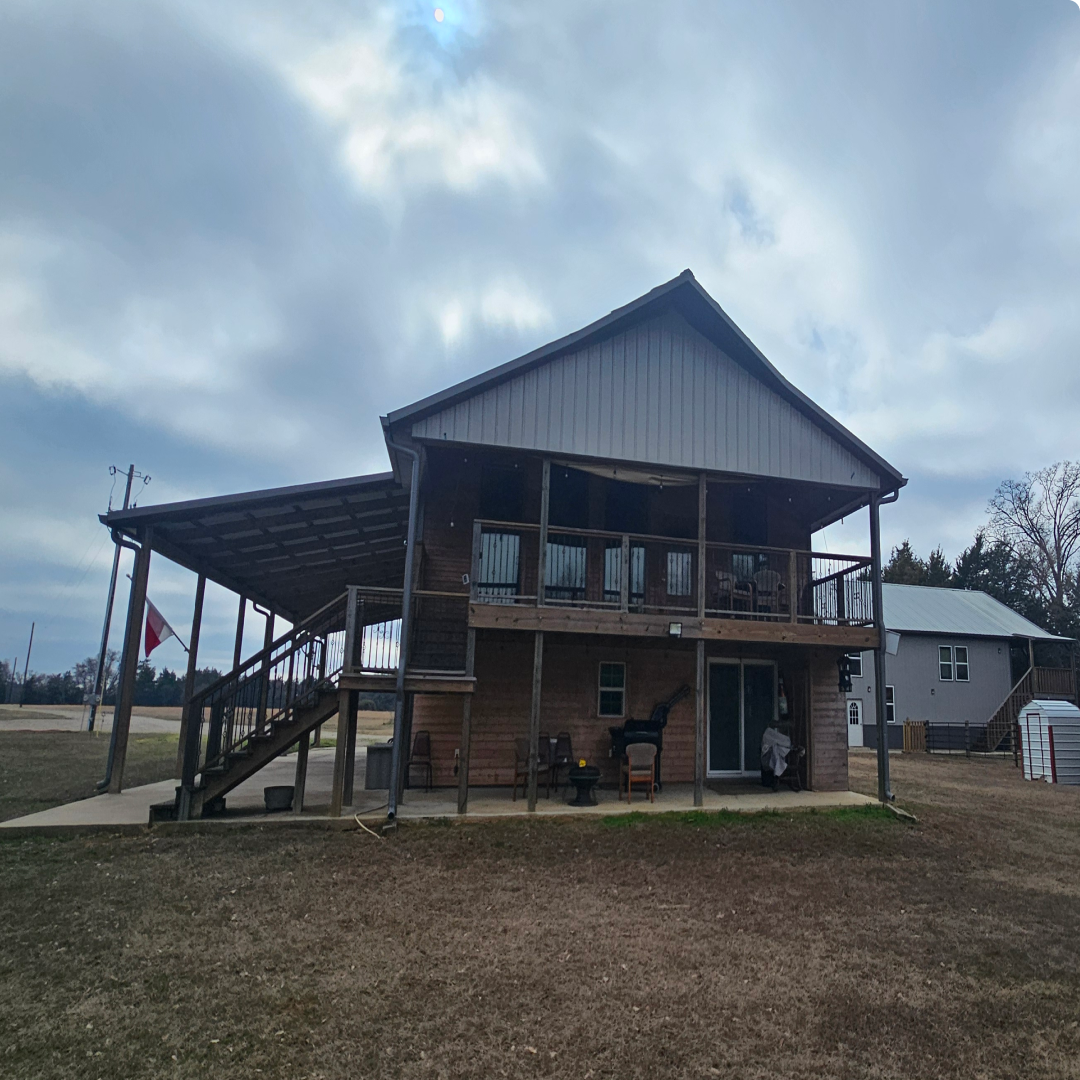 Modern two-story luxury cabin rental Rancho 2 at Pinoy Ranch, featuring a spacious elevated deck and covered outdoor living area in Canton, TX.