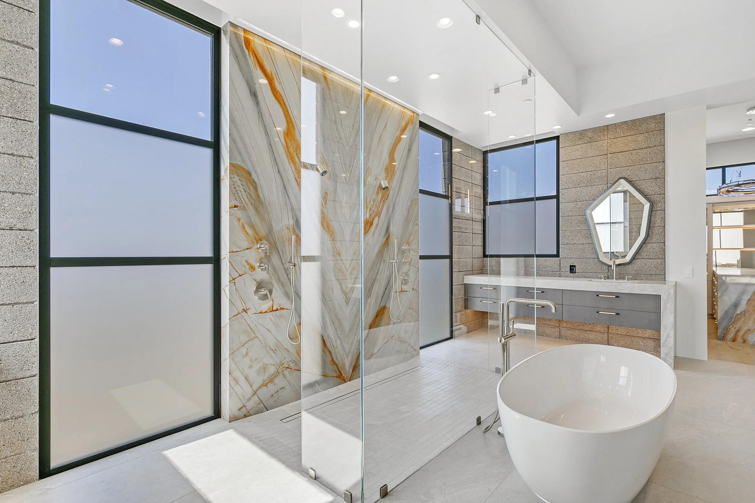 Modern frameless glass shower enclosure in a bright bathroom