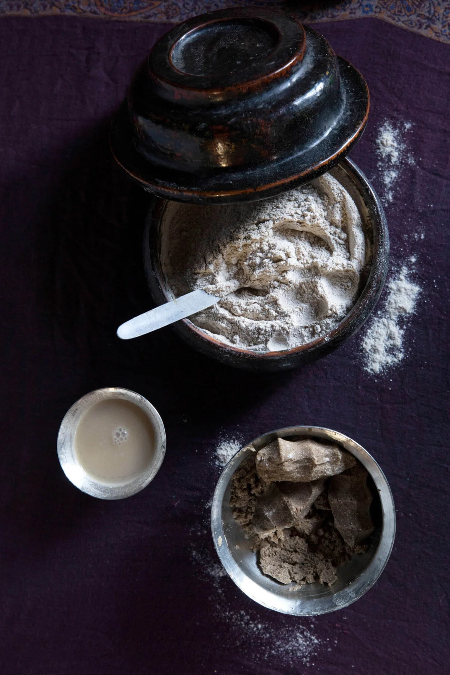 Butter tea and tsampa laid out in dark vessels