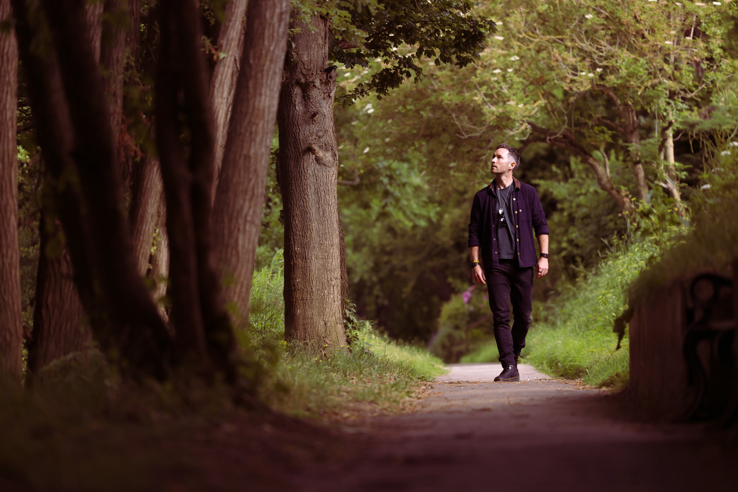 Sam Tate walking a woodland path