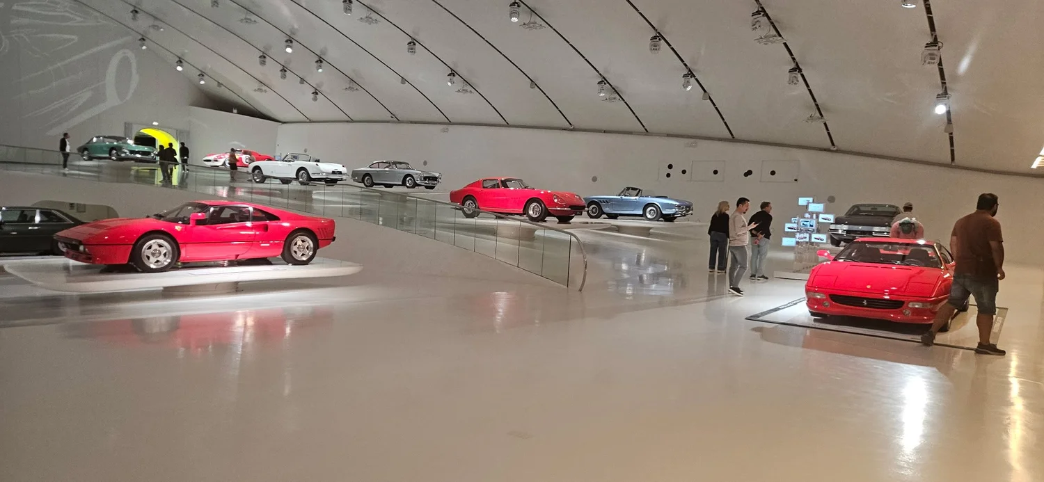 A long curving gallery of classic and modern Ferraris at Museo Enzo Ferrari