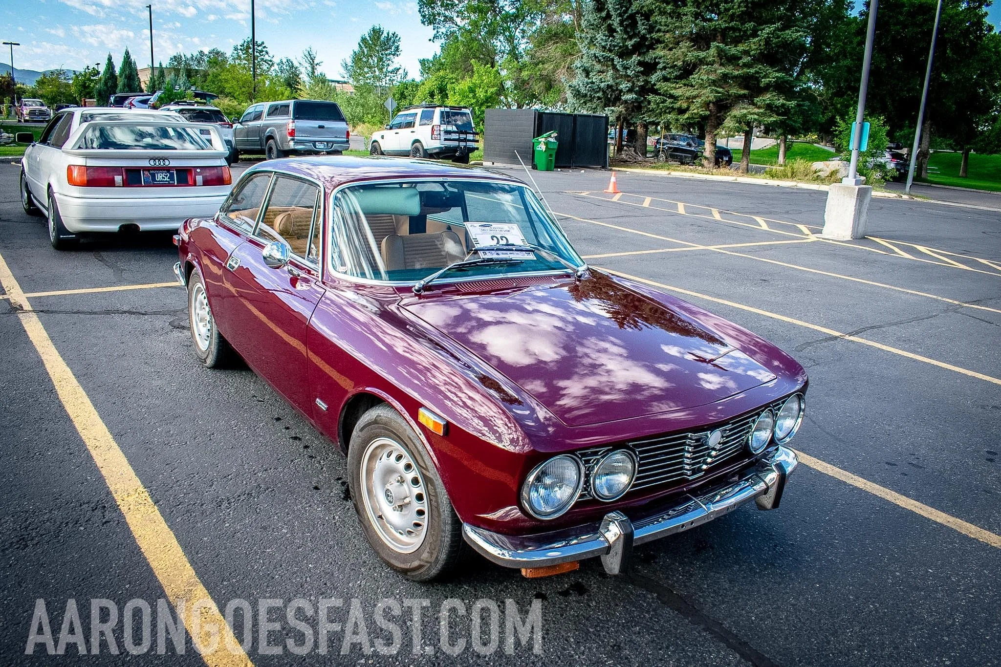 Classic maroon Alfa Romeo coupe parked in a lot, front angle