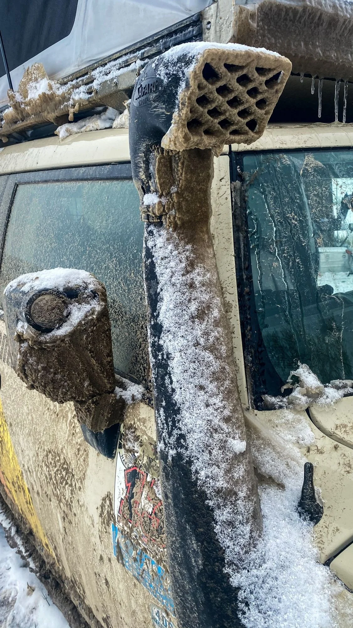 Close view of a mirror and snorkel caked in frozen mud and snow on a 406 Cruisers run in the upper Ruby River country, Montana