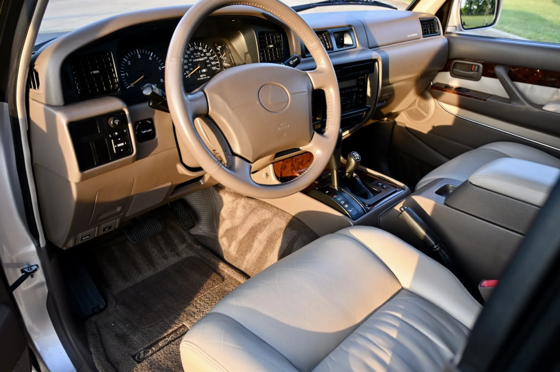 Ivory leather front seats and dashboard of the 1997 Lexus LX450 with the diff lock switch
