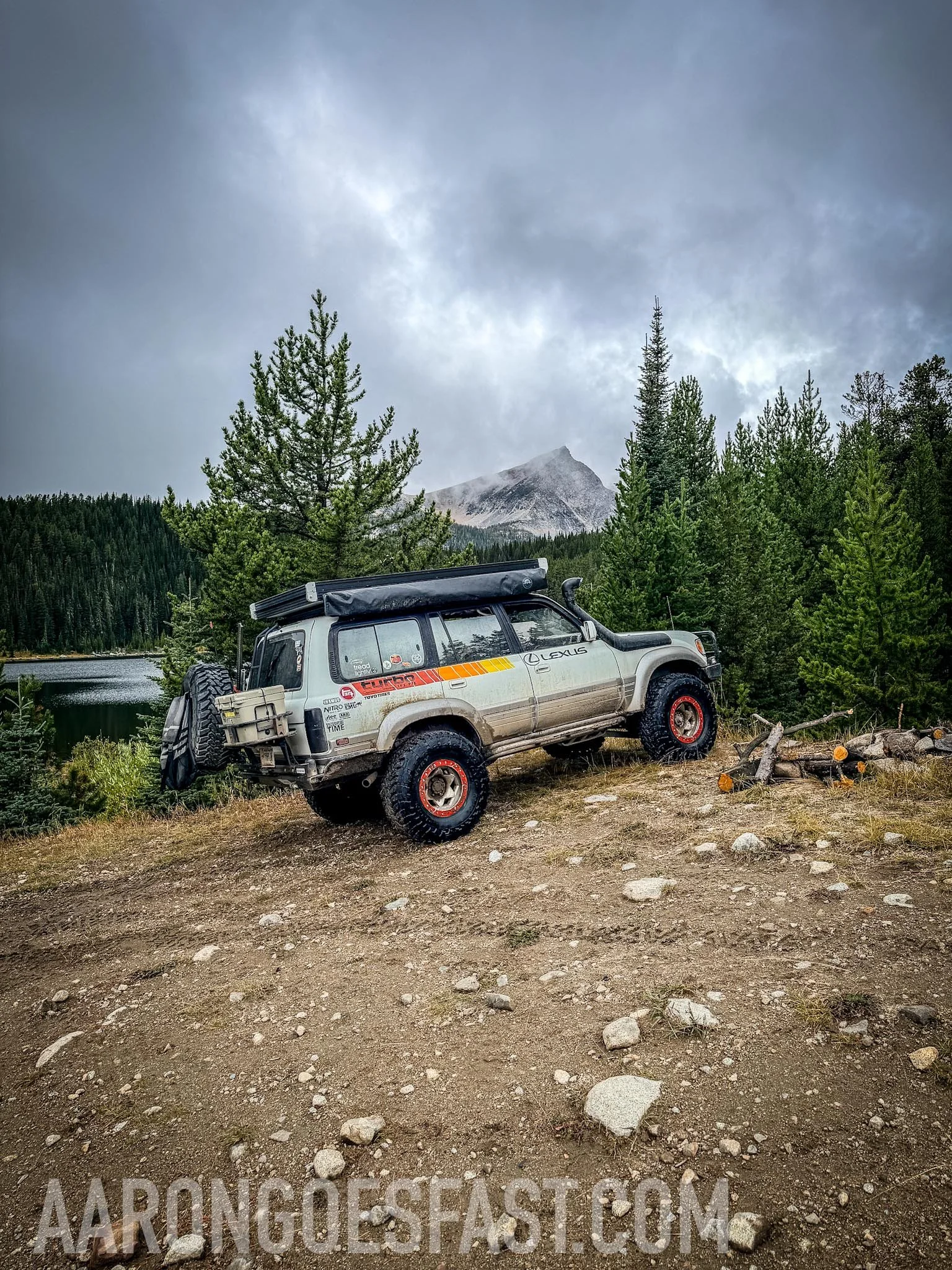 The Lexus LX450 parked above Twin Lakes with a snow-capped peak and storm clouds behind it