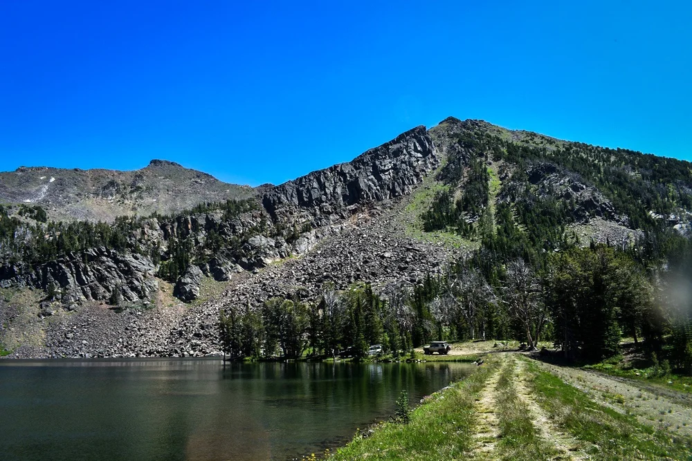 Dirt two-track running beside the lake below talus slopes