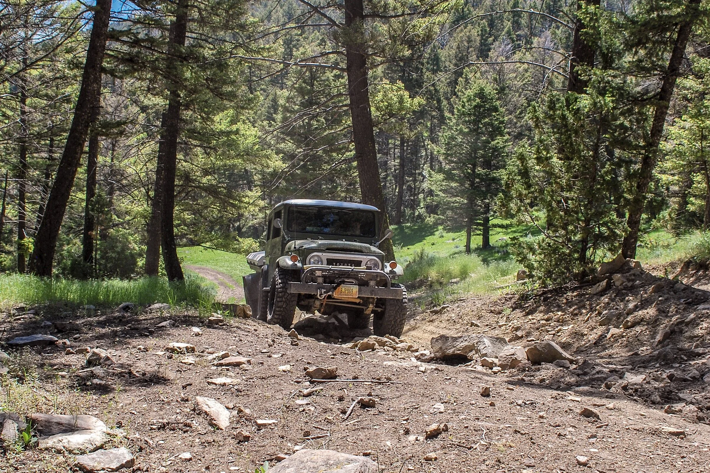 Four-wheel-drive Toyota traveling the rocky Ringing Rocks access road through a forest