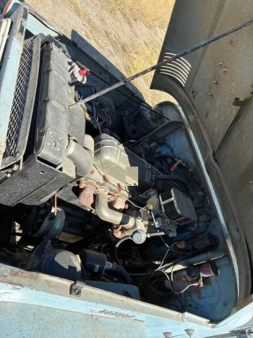 Engine bay of the 1967 FJ40 showing the inline six-cylinder engine and aftermarket carburetor