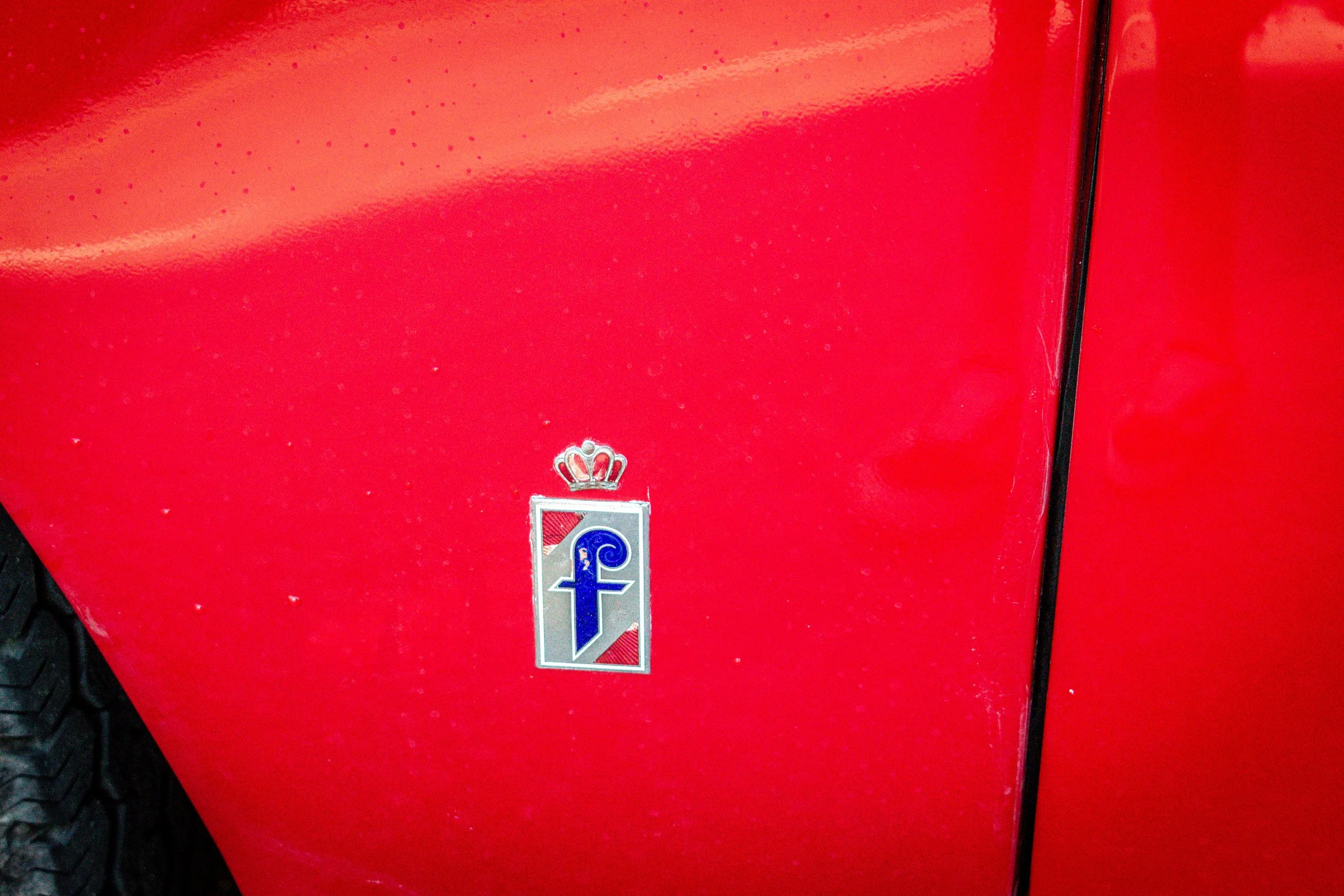 Close-up of the Pininfarina crown and f badge on the front fender
