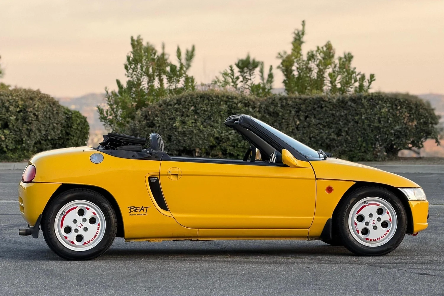 Side view of the Carnival Yellow 1991 Honda Beat with the top down