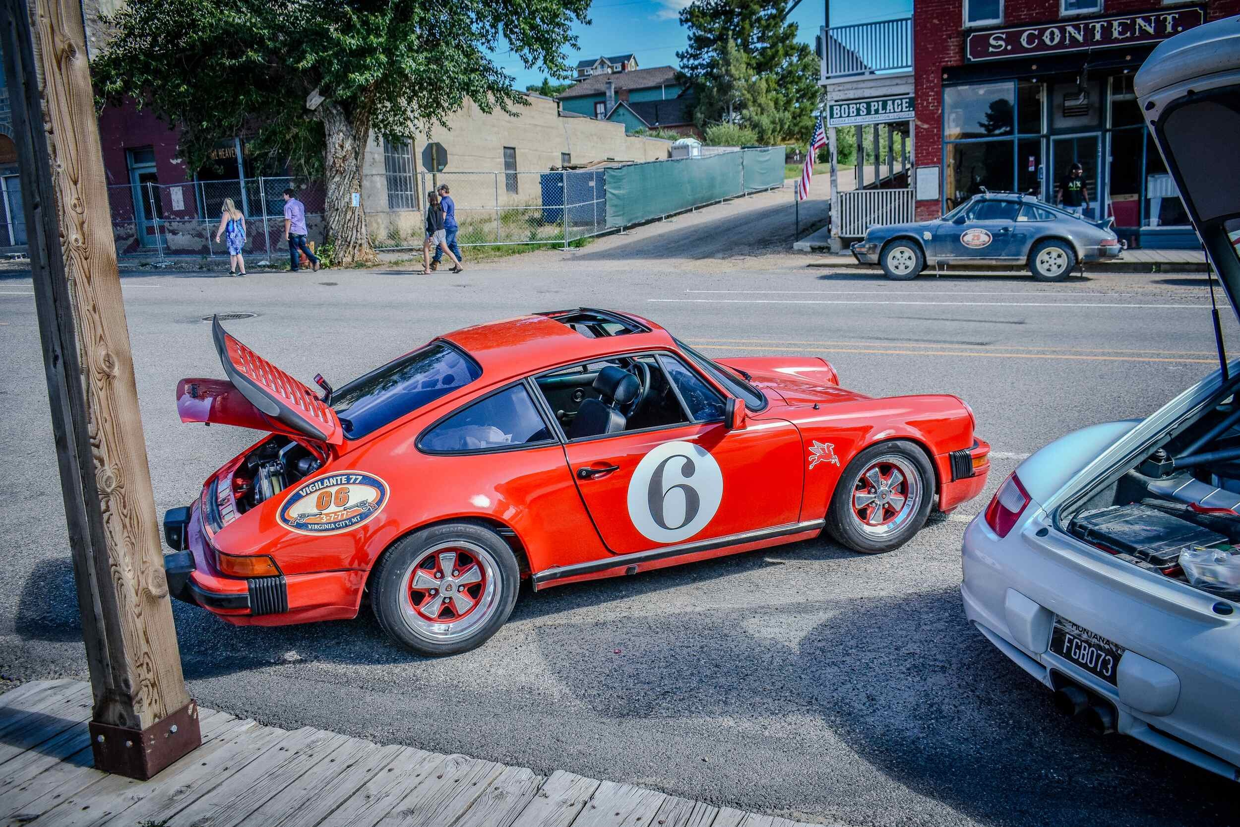 Red number six Porsche 911 with its hood open in Virginia City