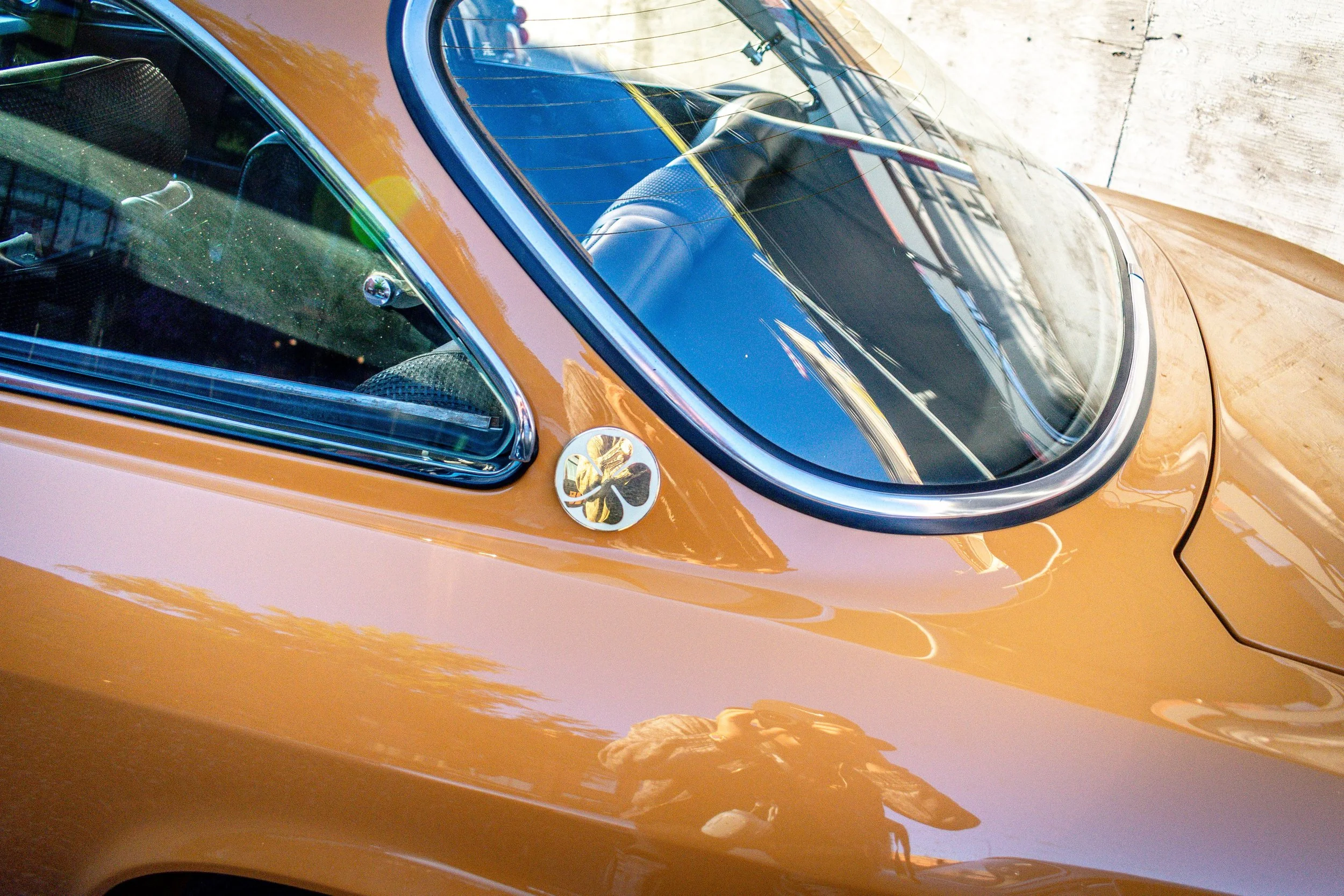 Close-up of a four-leaf clover quadrifoglio badge on the C-pillar of the Alfa Romeo