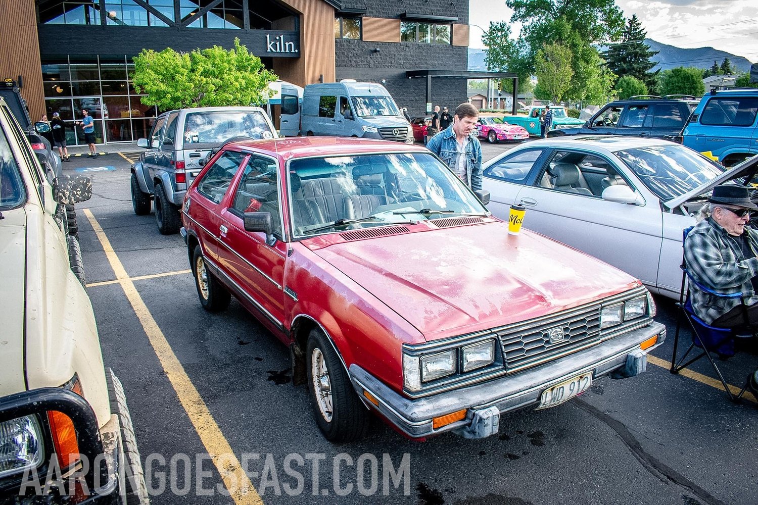 Faded red Subaru GL hatchback at the Roly-Poly Daily Driver Show in Bozeman