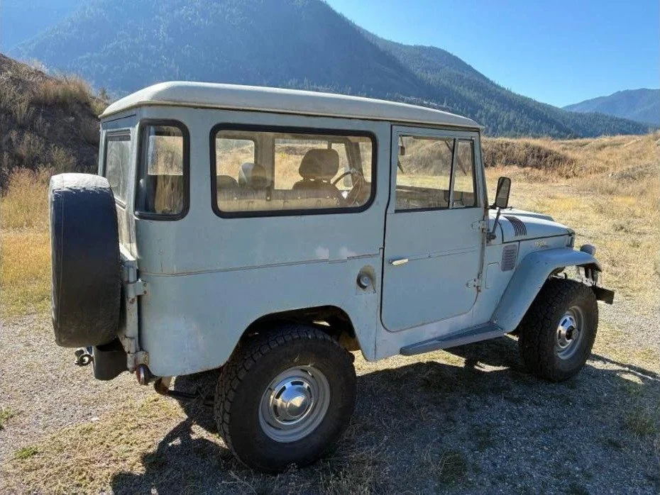 Side profile of the 1967 FJ40 hardtop in light blue with a white roof and mountains behind