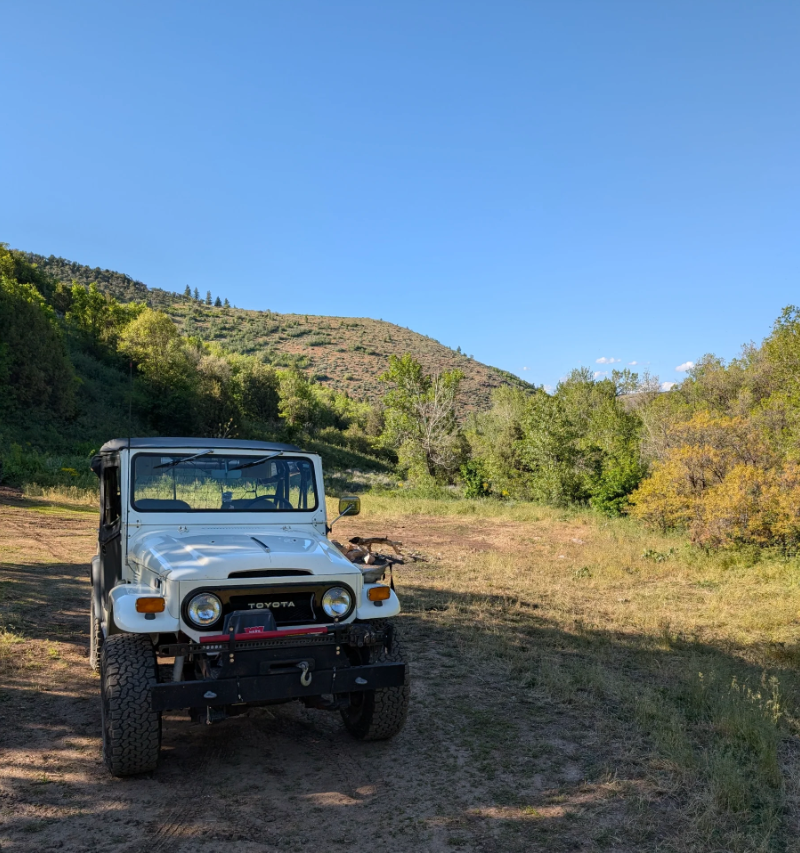White 1974 Toyota FJ40 from Ogden, Utah, parked in a green mountain valley