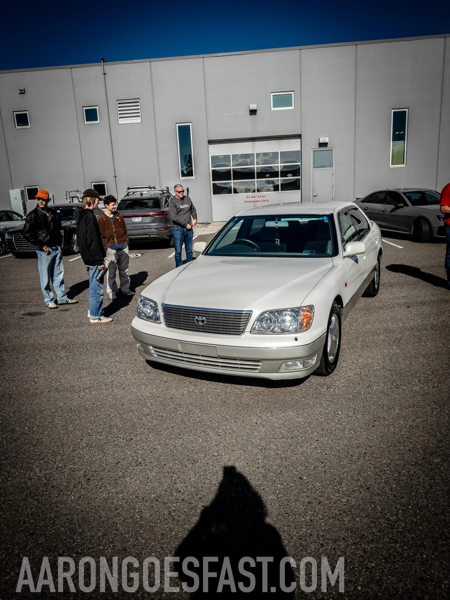 White Lexus LS400 with a small crowd around it