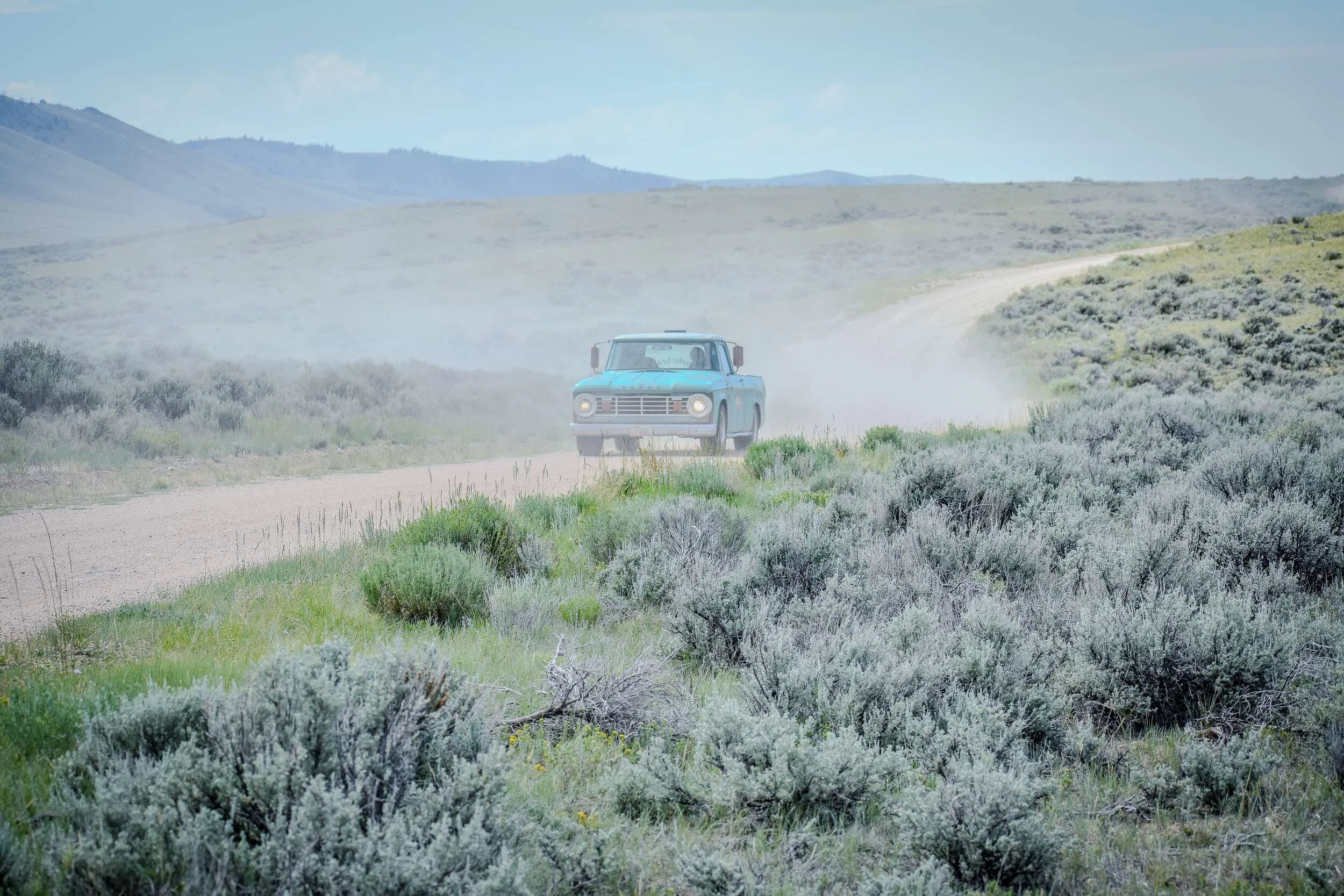 Wide view of a turquoise vintage Dodge and Crown Victoria chassis build in Montana dust