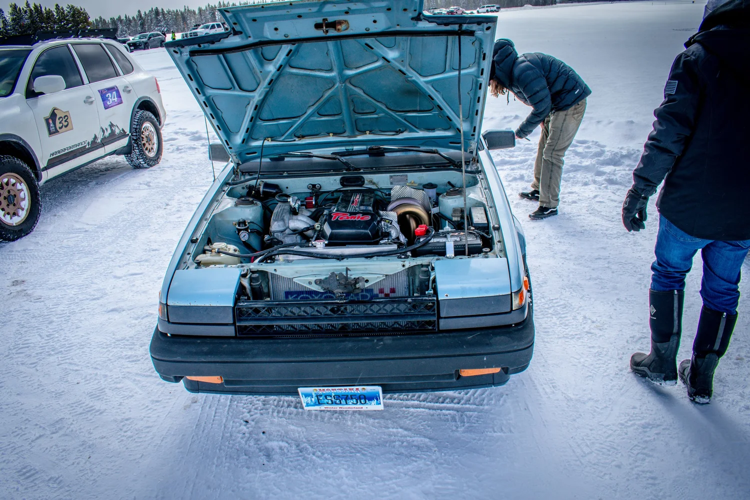 1980s Toyota Corolla with the hood open on the ice at the Frost and Furious ice races in West Yellowstone