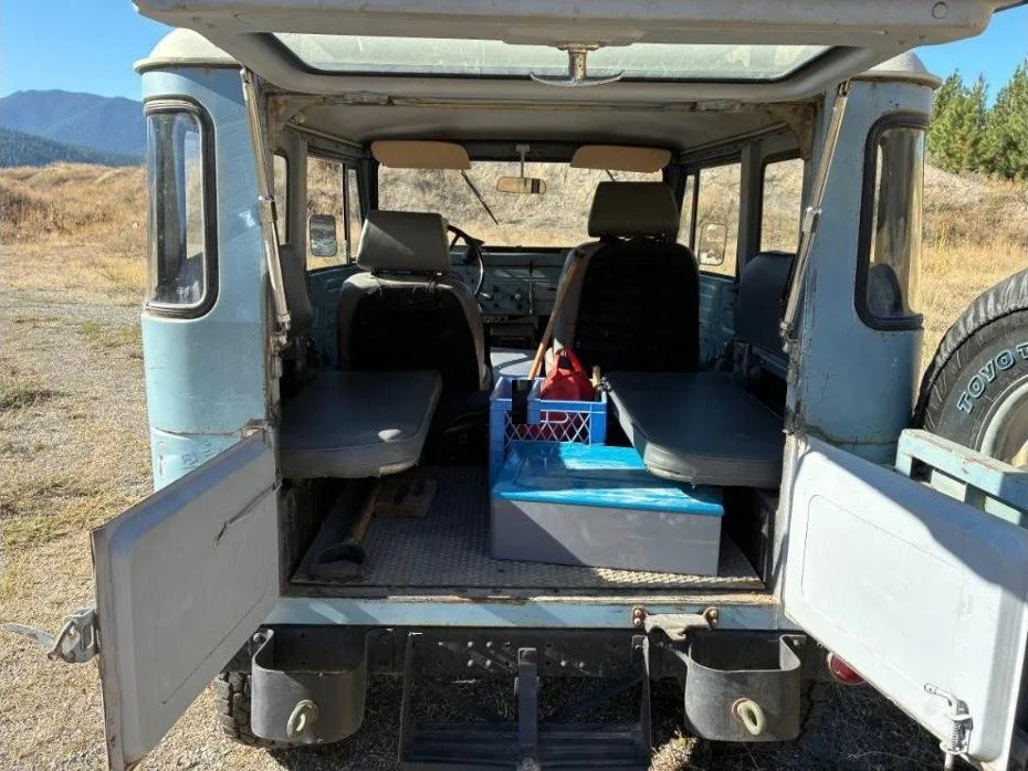 Rear barn doors open on the 1967 FJ40 showing the rear jump seats and cargo floor