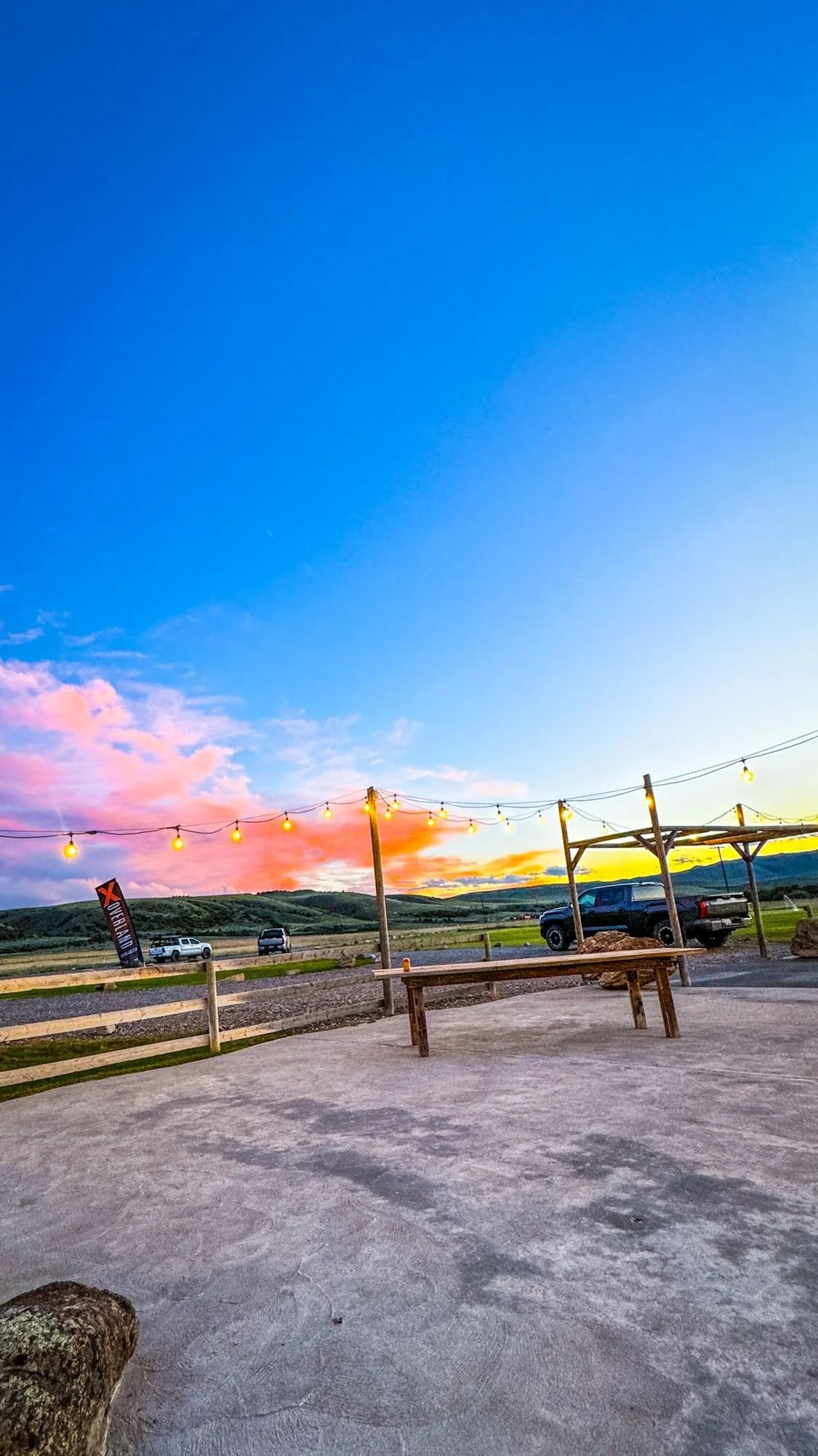 Pink sunset over a ranch patio with a picnic table at XOverland Ranch near Bozeman, Montana