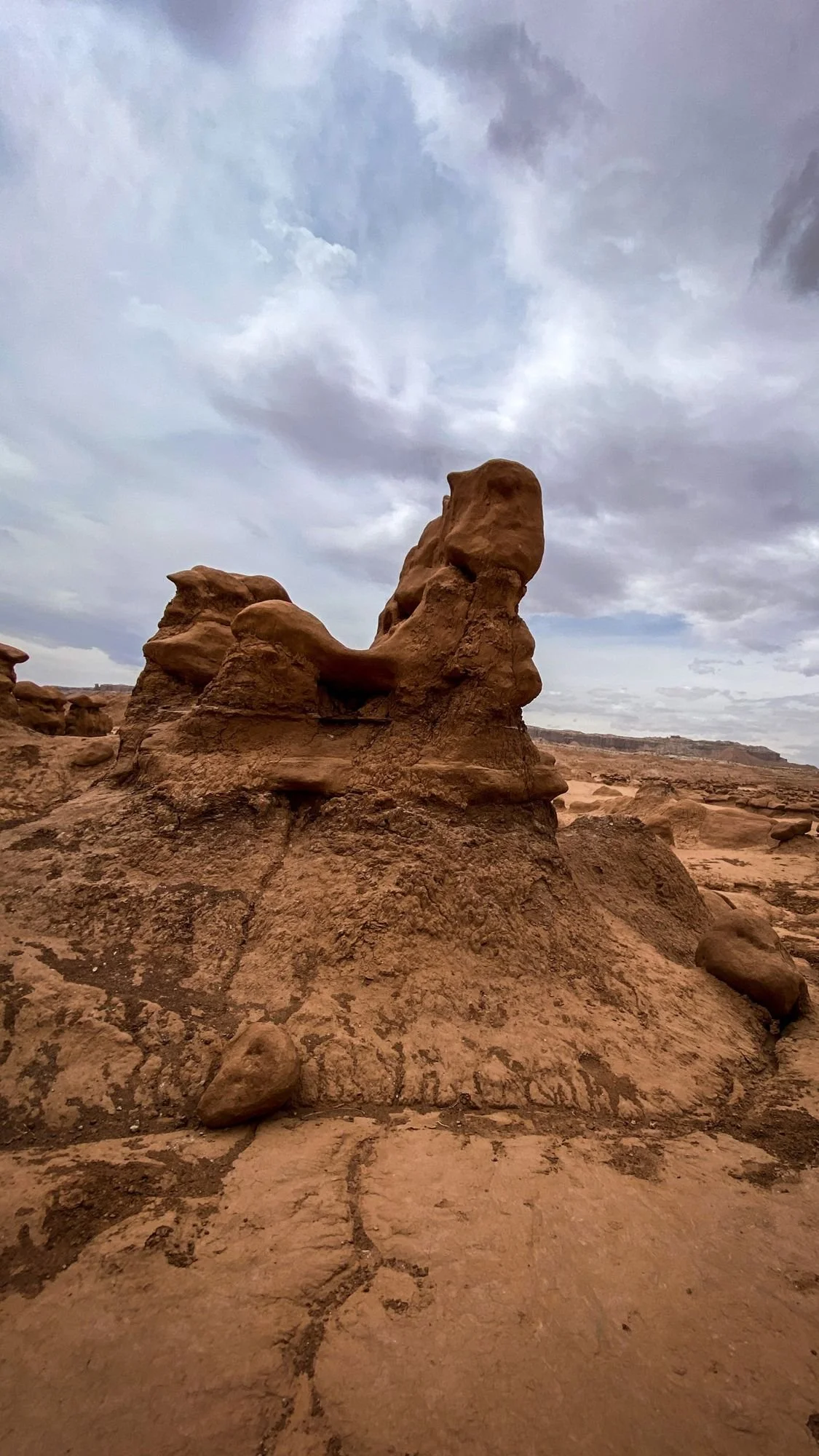 Two lumpy sandstone hoodoos on a bare red rock flat in Goblin Valley State Park, Utah