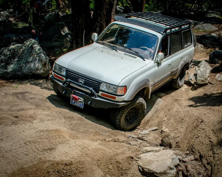 An 80 Series Land Cruiser climbing over rock embedded in the trail at Ringing Rocks.