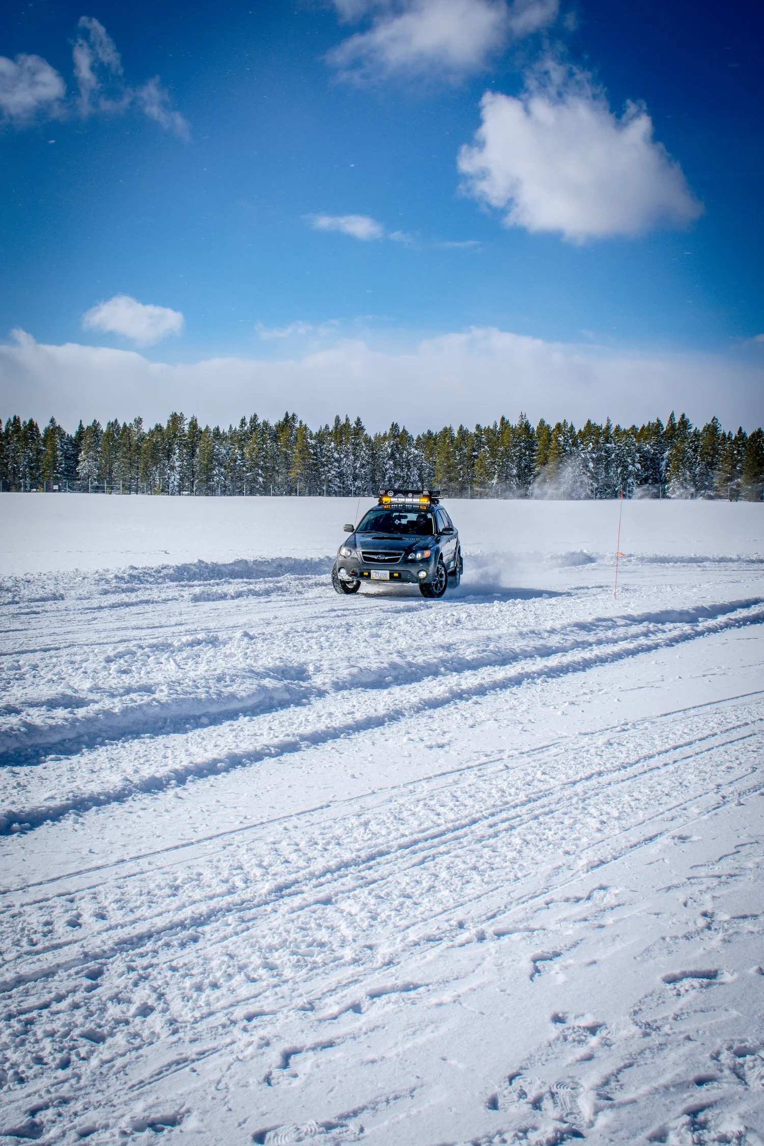 Gray Subaru Impreza with a roof light bar on the ice at the Frost and Furious ice races in West Yellowstone