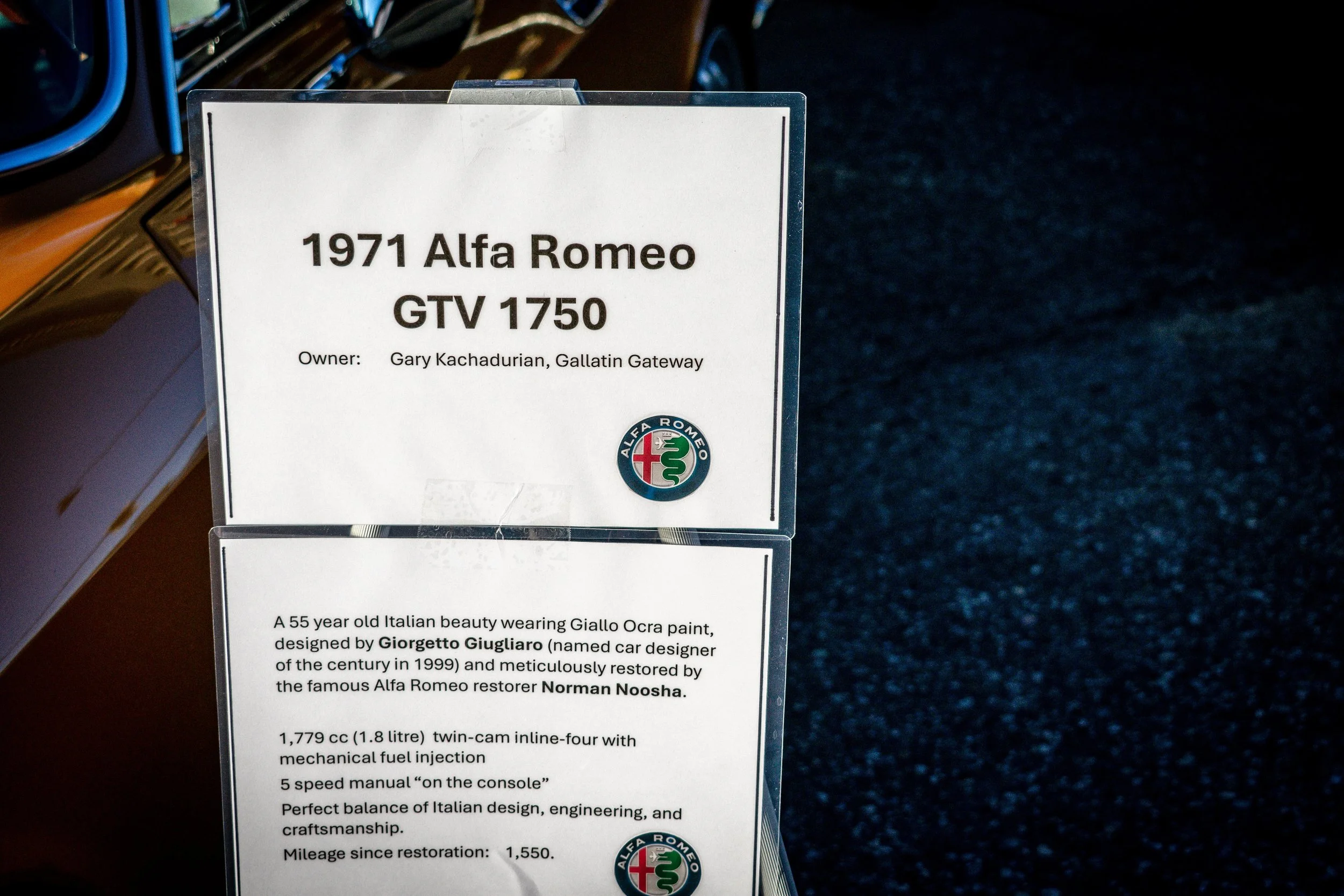 Show placard with details about the 1971 Alfa Romeo GTV 1750, owner Gary Kachadurian, and restoration by Norman Noosha