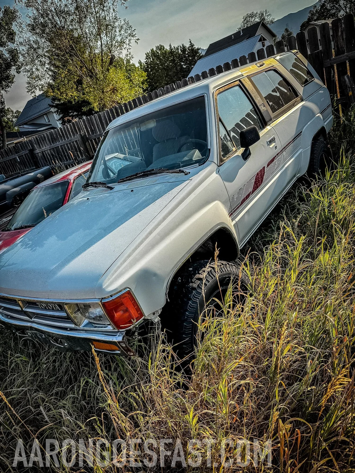 White first-generation Toyota 4Runner parked in tall grass