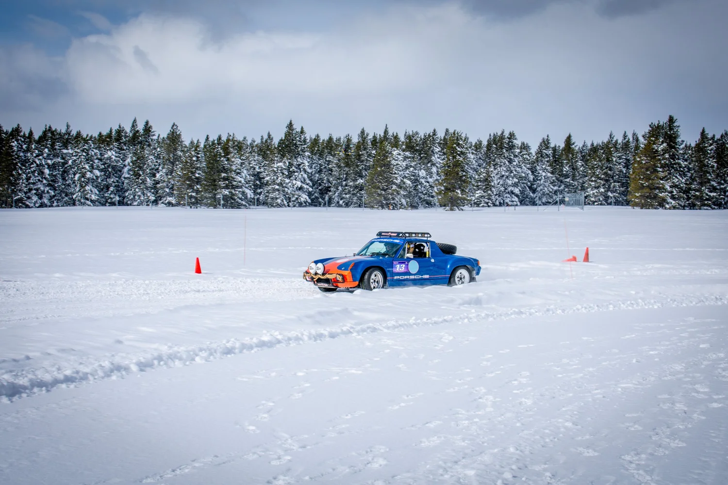Blue Porsche 914 rally car sliding on snow at the Frost and Furious ice races in West Yellowstone