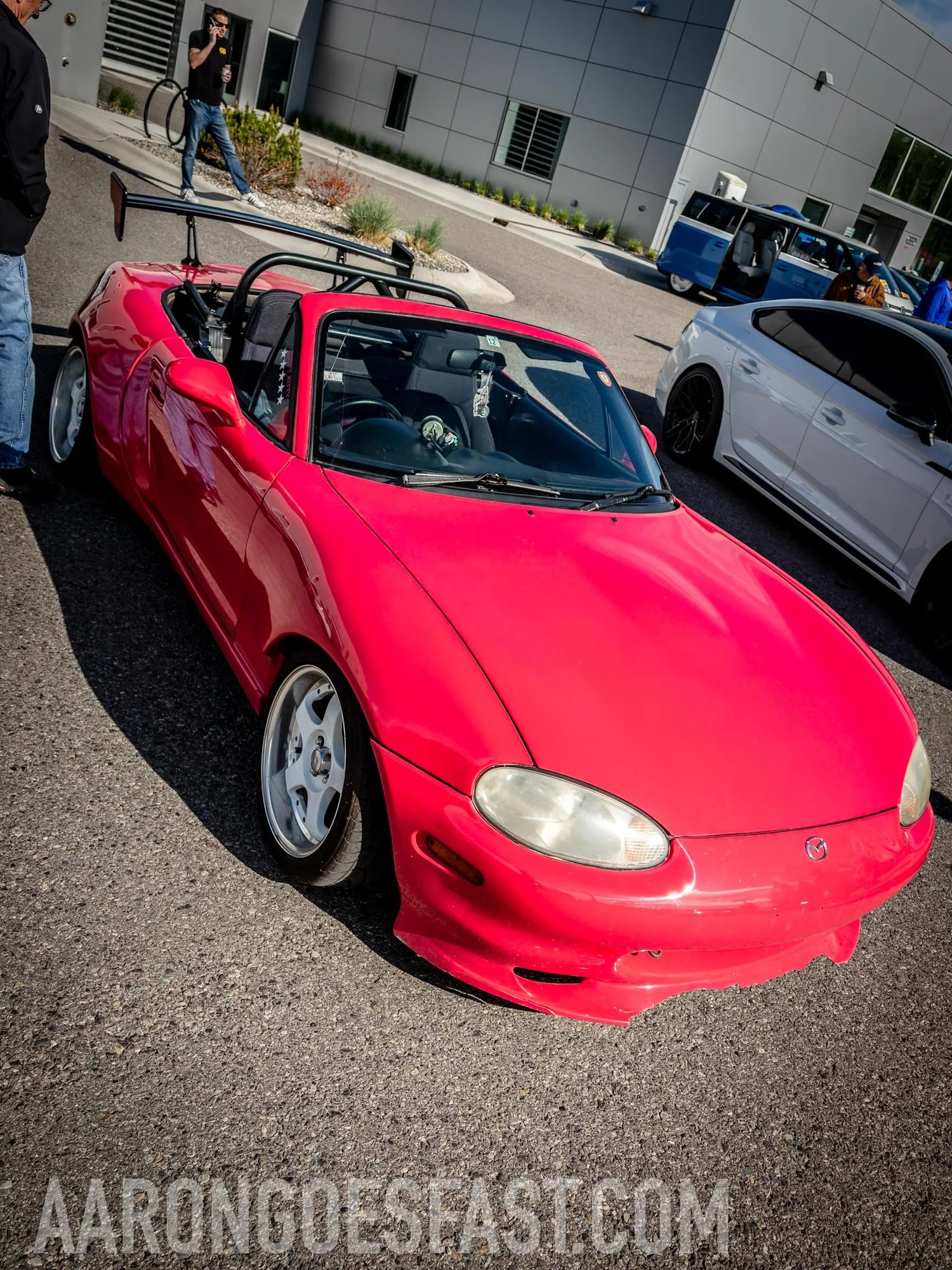 Pink Japanese-market Mazda Roadster with a roll bar and swan-neck wing