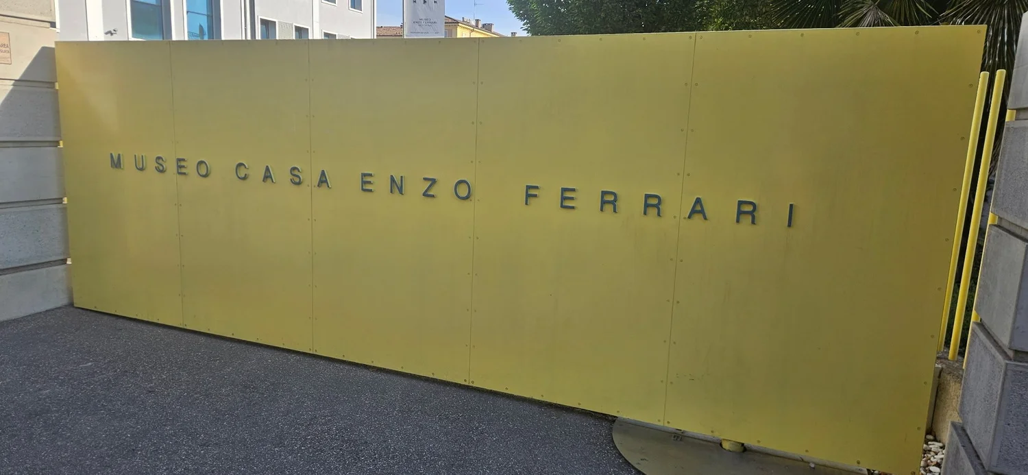The yellow Museo Casa Enzo Ferrari sign wall in Modena
