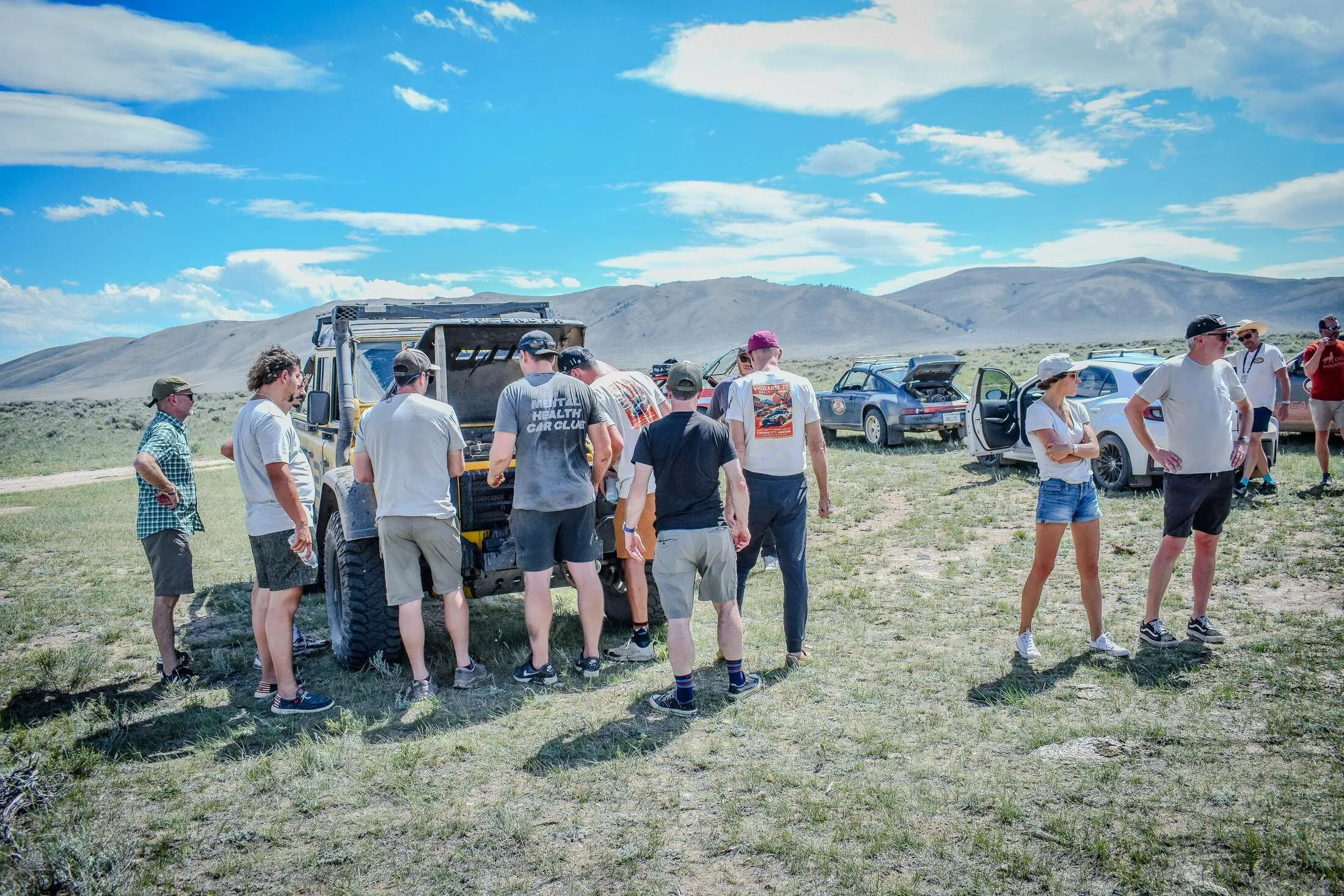 Sunday Dirt Crew participants regrouping beside their cars in open Montana country