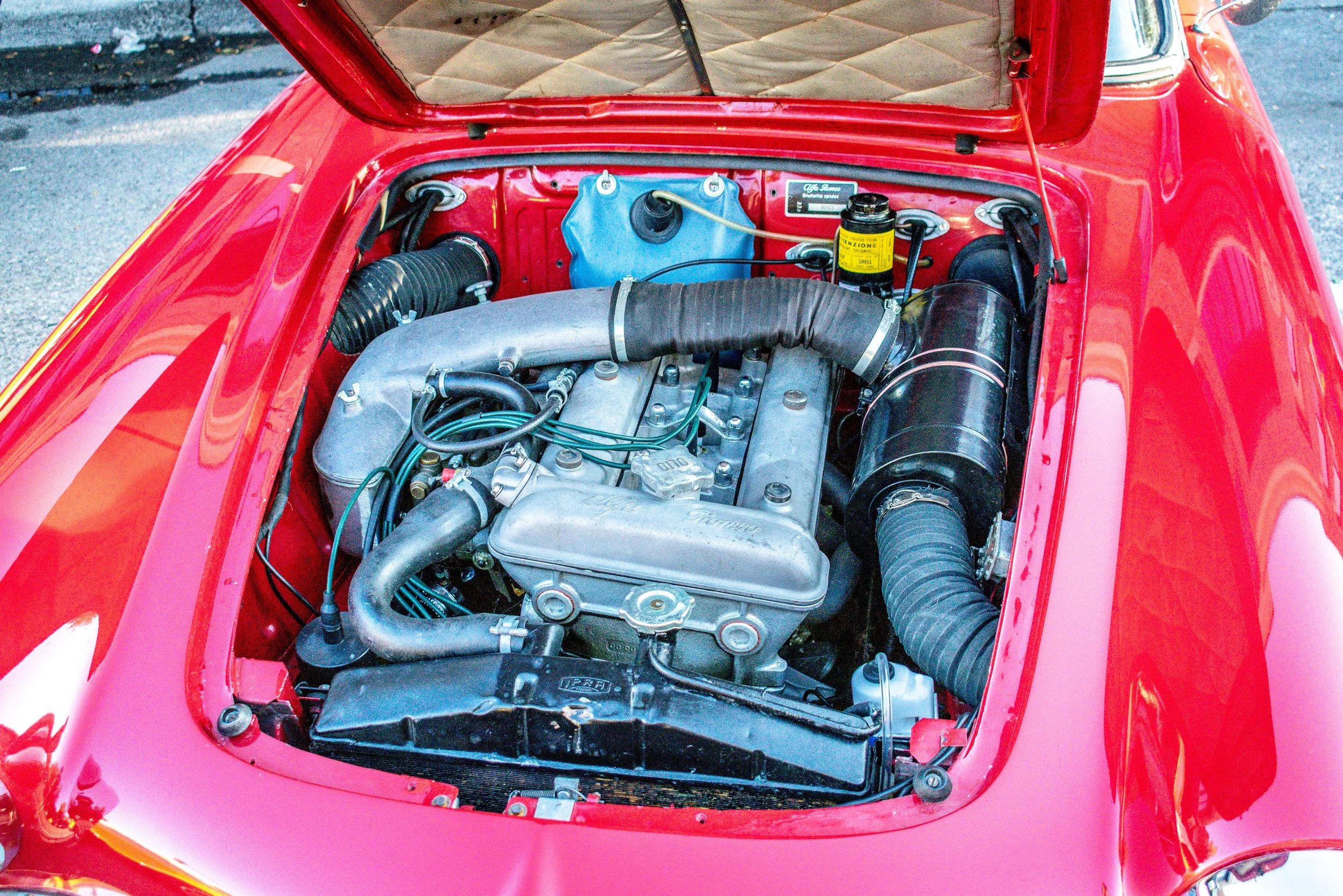 Wide shot of the engine bay with tan quilted trunk liner visible