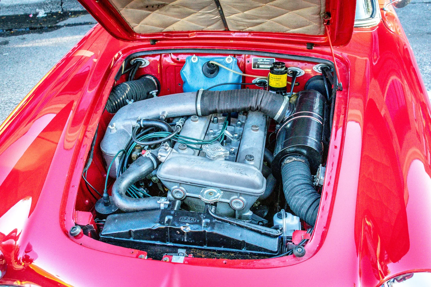 Wide shot of the engine bay with tan quilted trunk liner visible