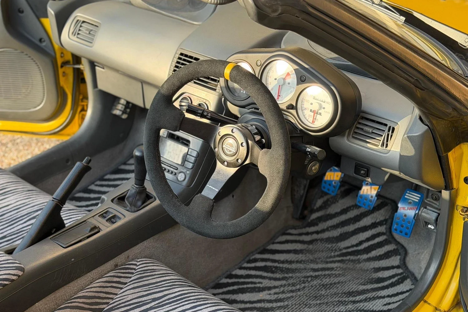 Steering wheel, gauges and zebra floor mats in the 1991 Honda Beat