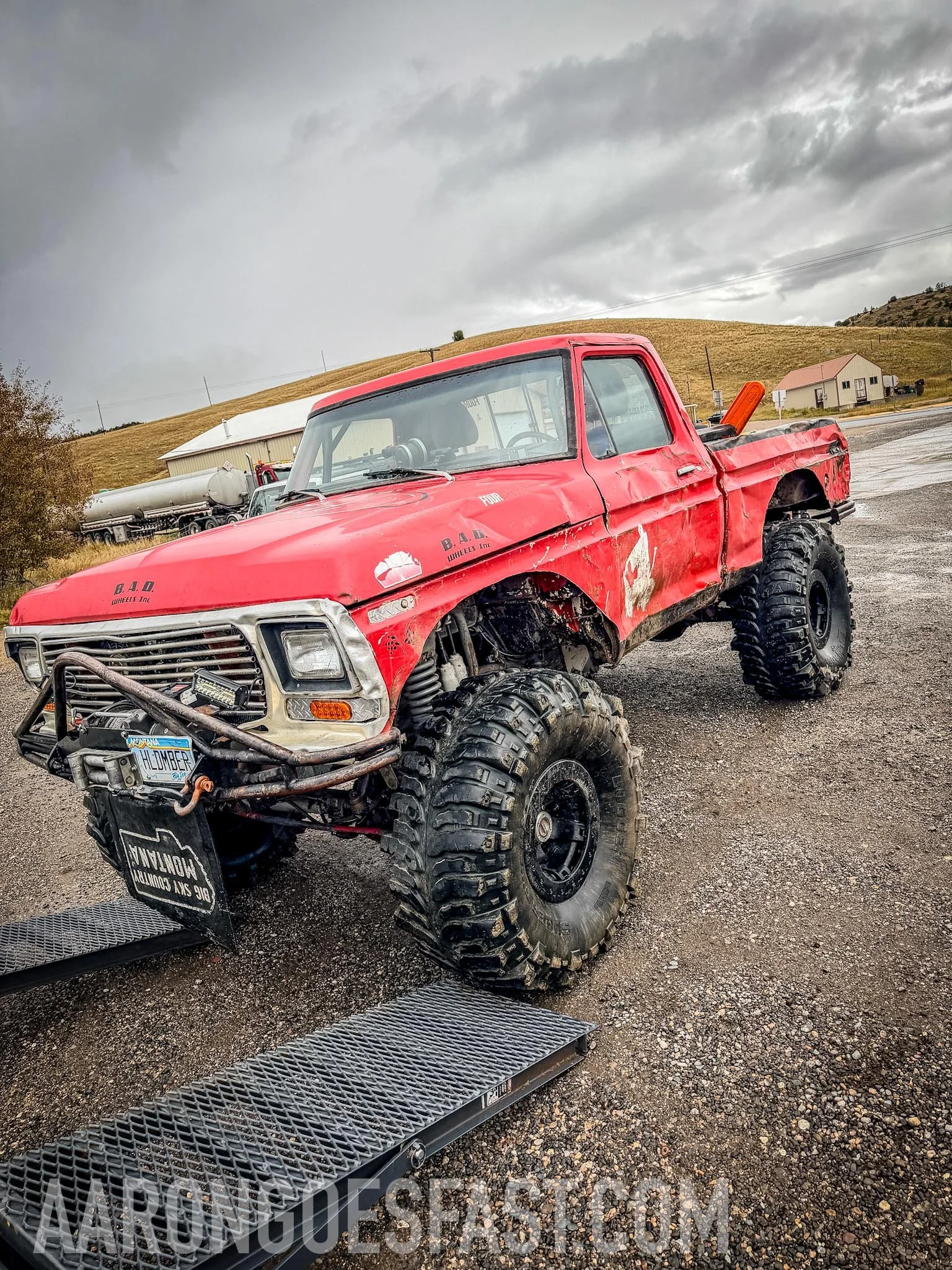 Red lifted 1970s Ford pickup on ramps at the Norris gas station