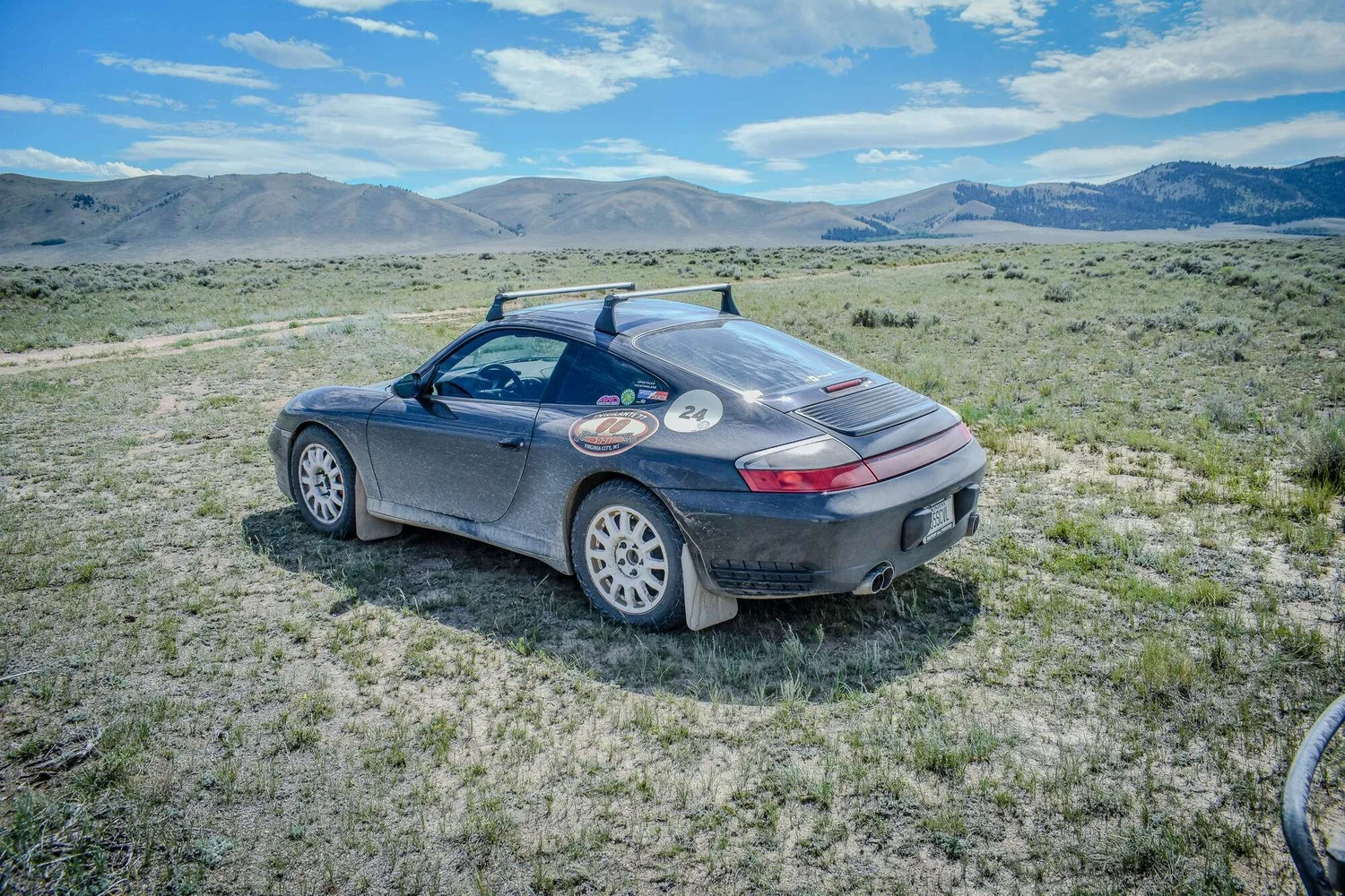 Silver Porsche 911 parked in open Montana country during the rally