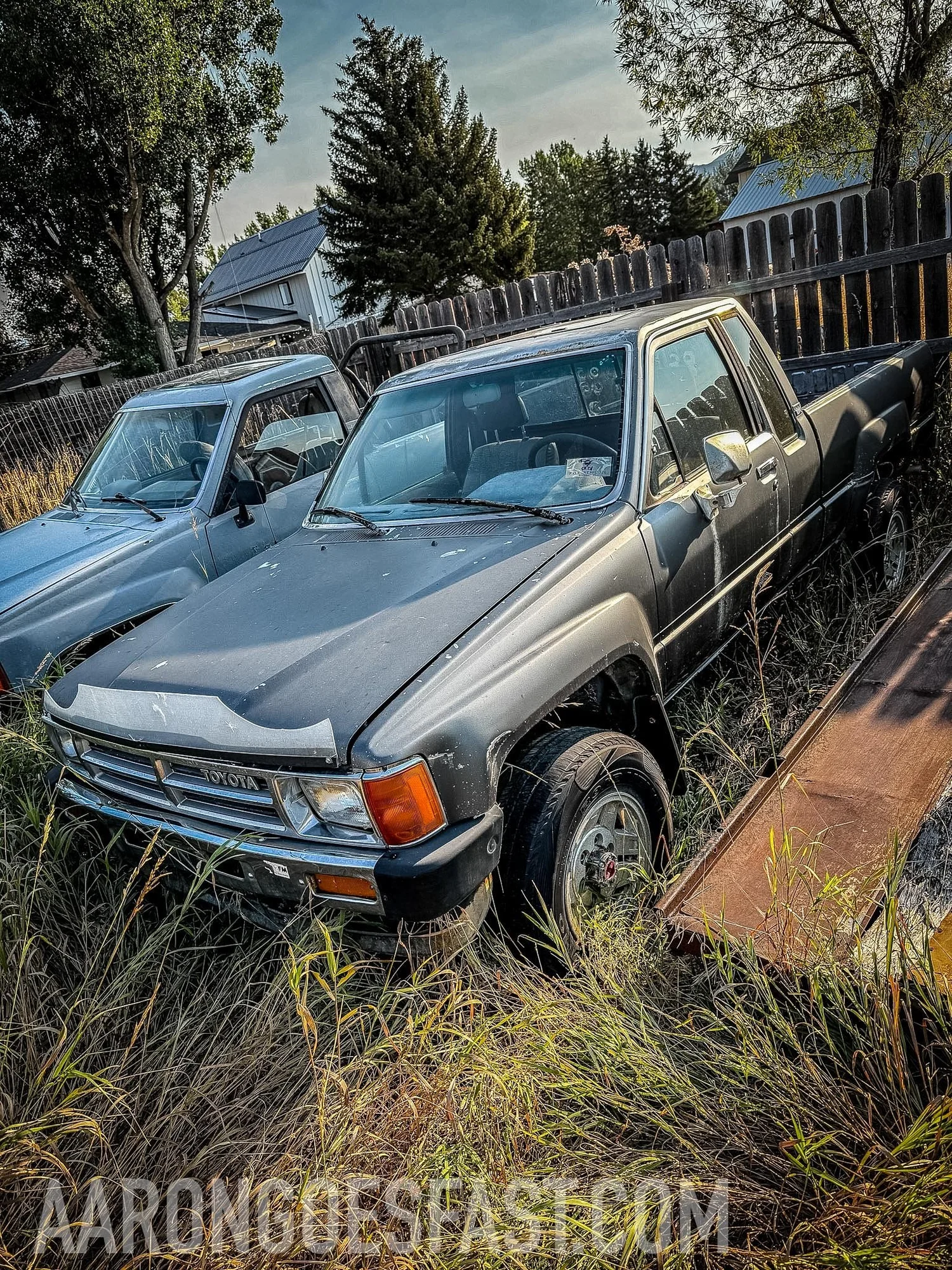 Gray first-generation Toyota parked beside a light blue one