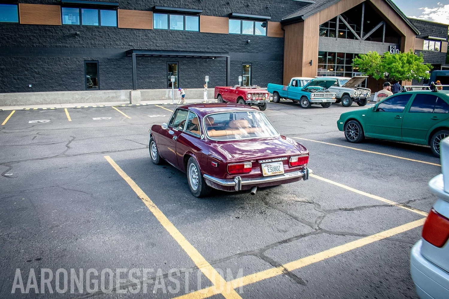 Wide rear angle of maroon Alfa Romeo parked in a lot