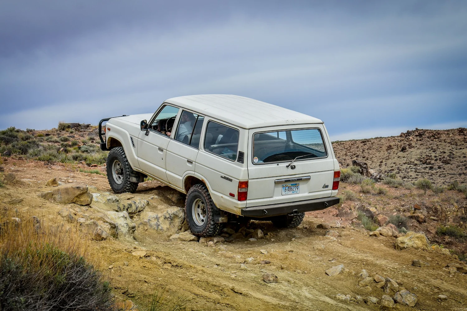 White 60 Series Toyota Land Cruiser climbing slickrock on the 3D Trail at Cruise Moab