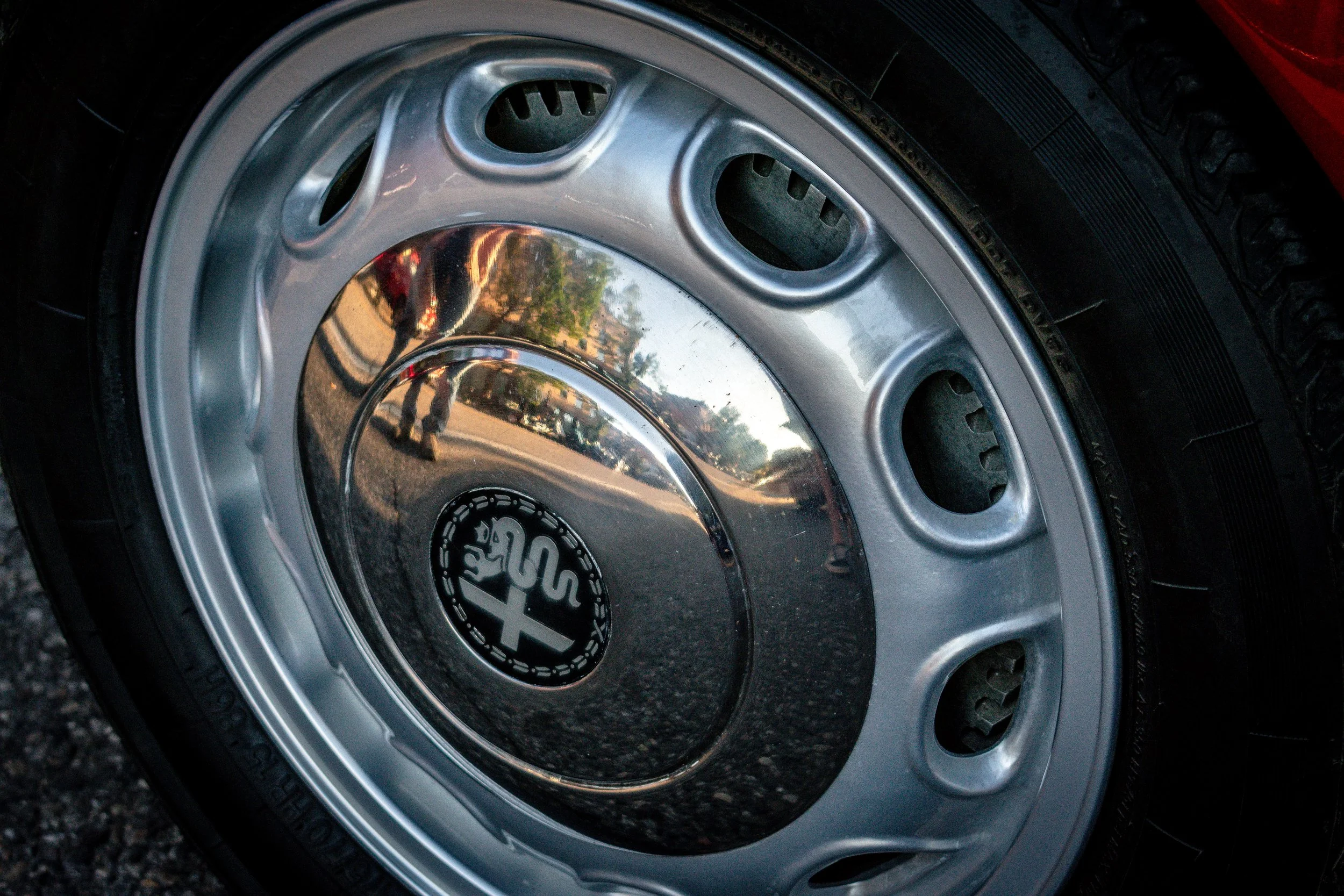 Close-up of the steel wheel and hubcap with the Alfa Romeo Biscione medallion