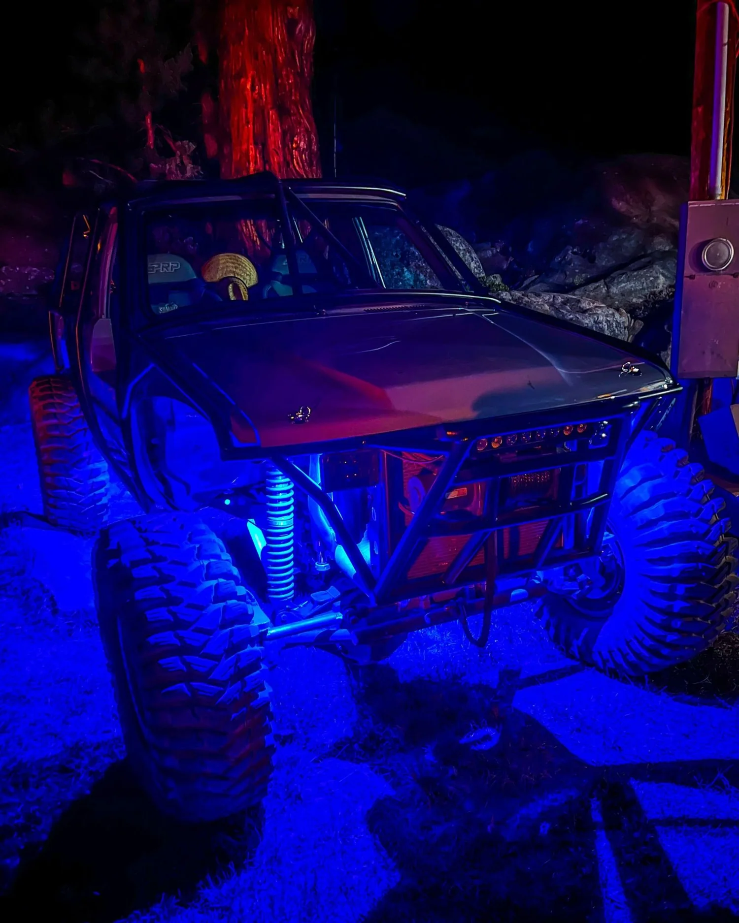 Lifted truck glowing under blue rock lights at night on the Rubicon Trail in California during Rubithon 2022