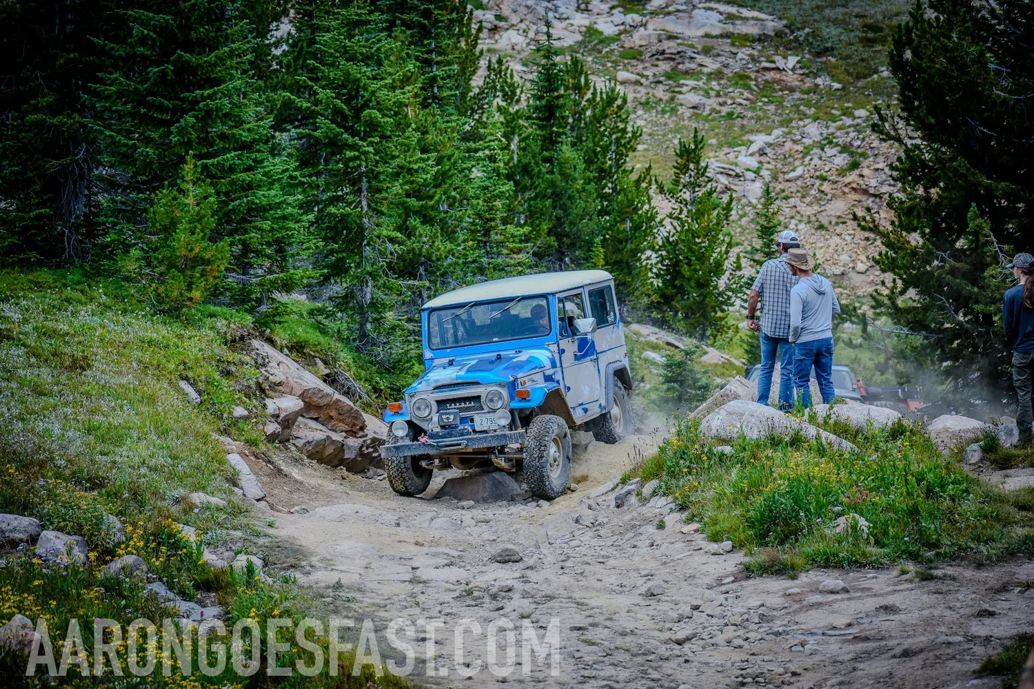 Blue and white 1971 Toyota FJ40 Land Cruiser on a rocky trail on the 406 Cruisers Goose Lake run near Cooke City, Montana