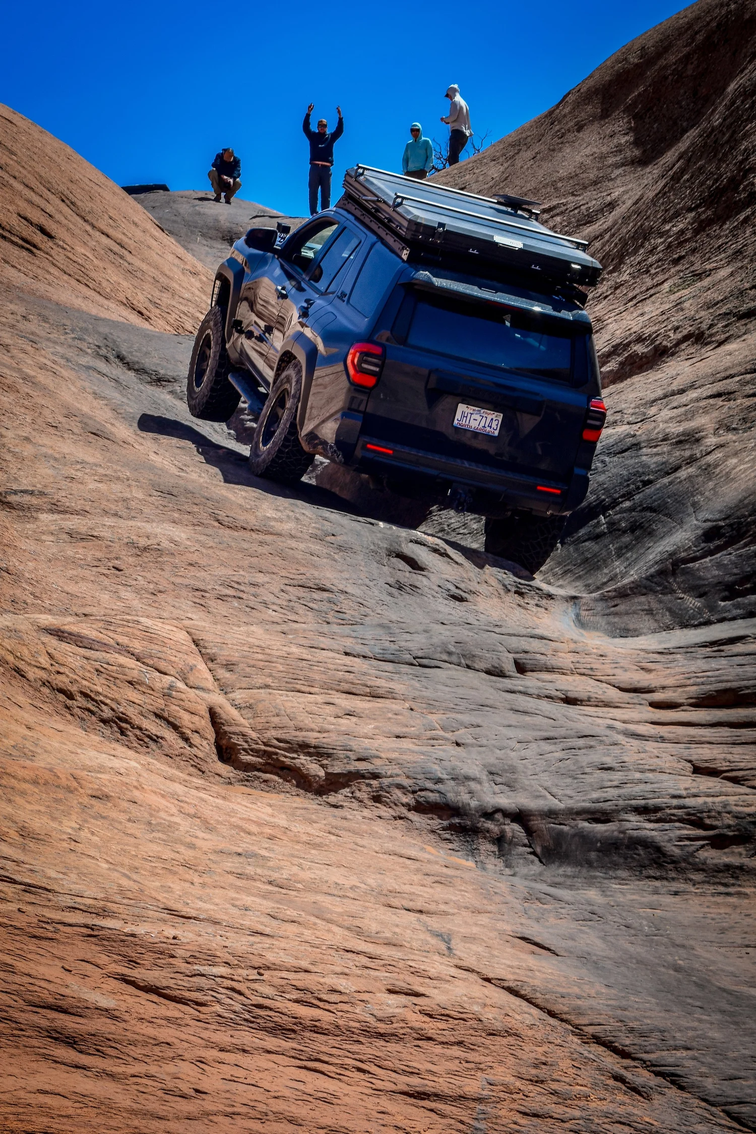 Toyota 4Runner climbing a slickrock ledge at Cruise Moab