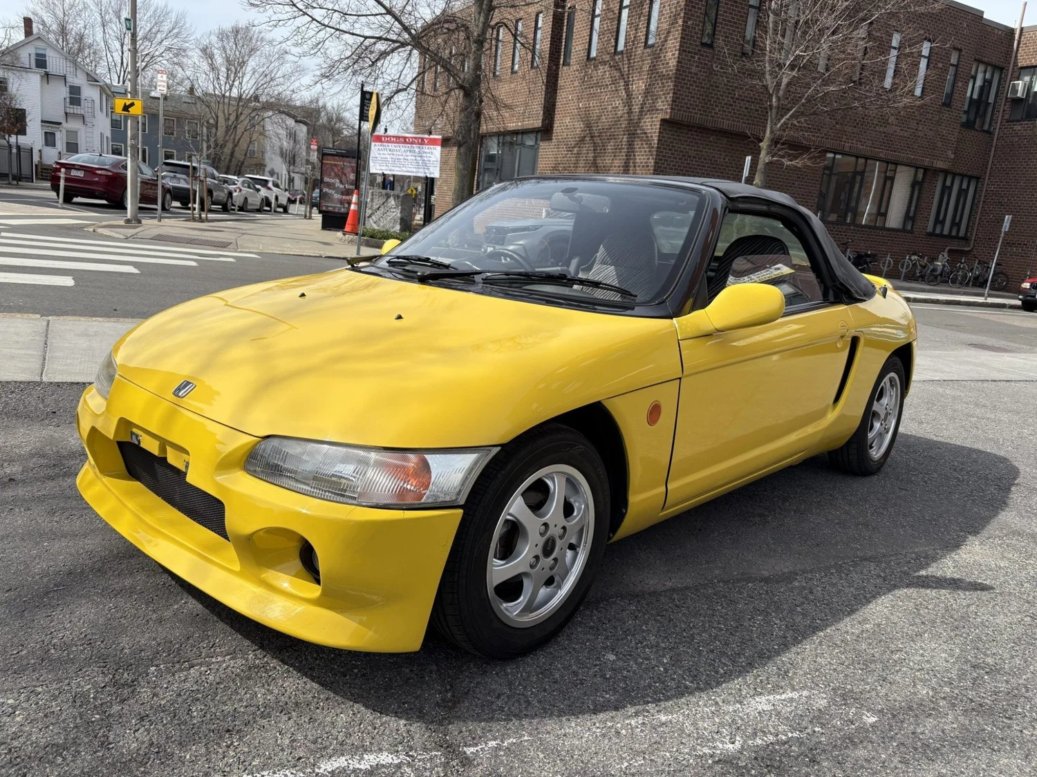 Yellow 1992 Honda Beat with black soft top parked on a street in Cambridge, Massachusetts