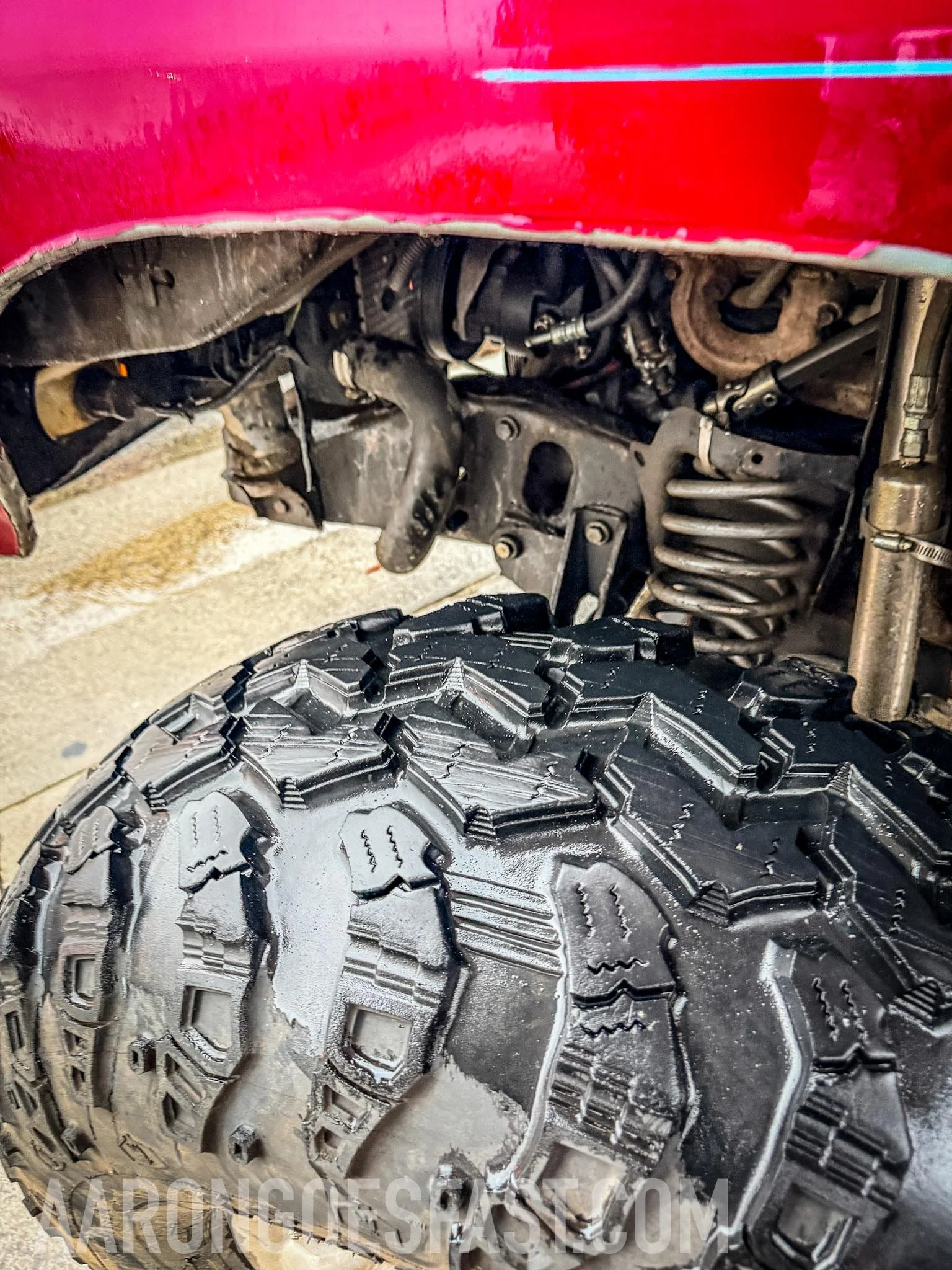 Close-up of tire and suspension underneath the red Ford