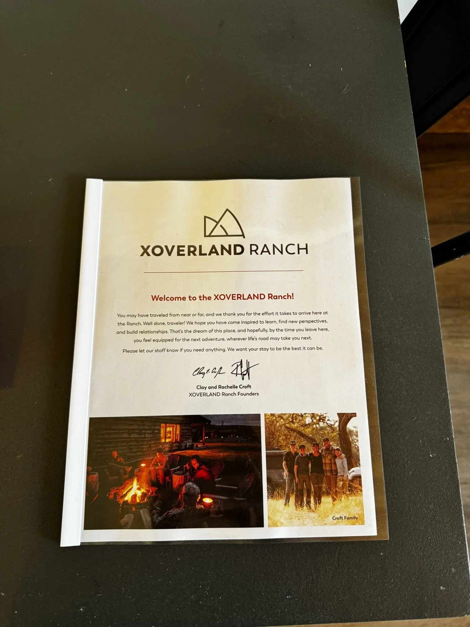 XOverland Ranch welcome letter with the ranch logo on a dark table