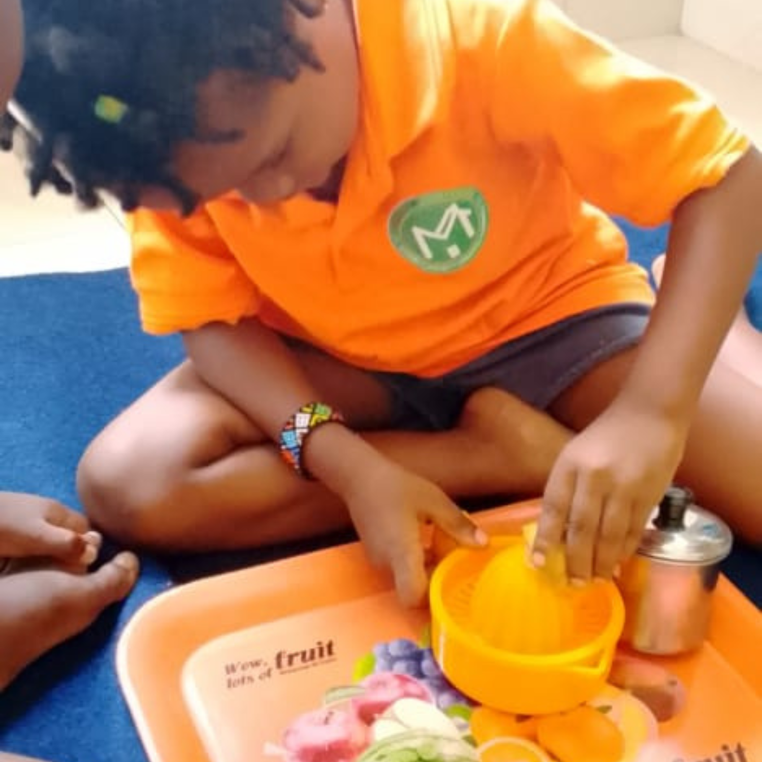 A child at House of Montessori Preschool practising an outdoor pouring activity